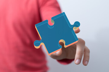 Image of a hand presenting a digital puzzle piece, symbolizing solutions, teamwork, and connection.