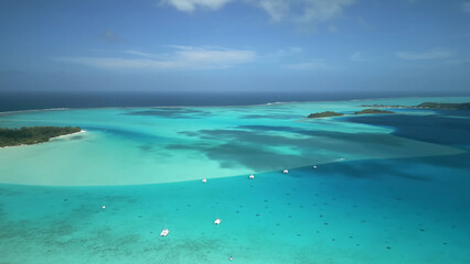 Luxury resort photo of Bora Bora tropical paradise islands with yacht, boat. Aerial 
perspective photography, coral reef, azure ocean, 
sky with clouds on horizon. French Polynesia.
Pacific Ocean.