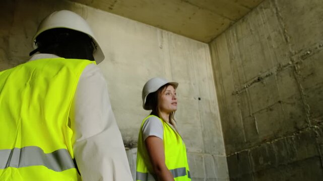 Female engineers climb steps of unfinished building. Ladies project managers prepare to analyze work result and evaluate quality of result