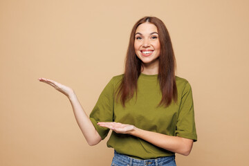 Young smiling happy woman she wears olive green t-shirt casual clothes point hands arms aside on...