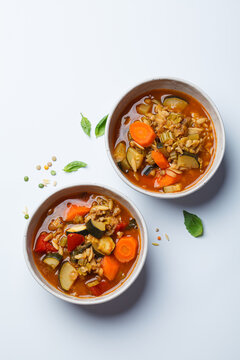 Vegetarian bean tomato soup with vegetables on white background.