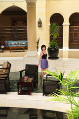 A slender woman in summer shorts in the lobby of a luxury hotel.