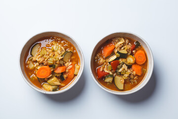 Vegetarian bean tomato soup with vegetables on white background.