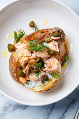 Whole baked potato stuffed with salmon, yogurt sauce and capers.