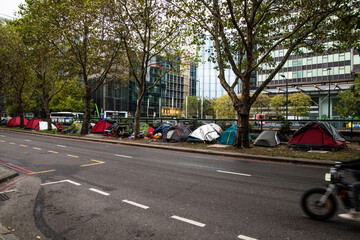 Tents of homeless people along Euston Road, London, highlighting urban poverty and rising...
