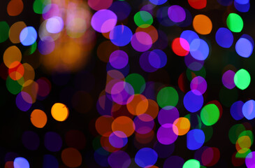 Colorful bokeh light effect on dark background creating a fun and festive atmosphere, perfect for party or holiday themes