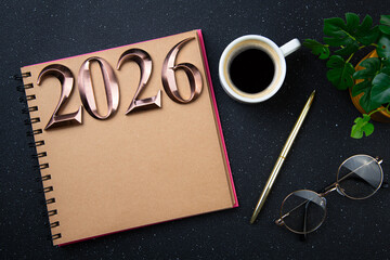 New year goals 2026 on desk. 2026 resolutions list with notebook, plant on black table. Resolutions, plan, goals, action, checklist, idea concept. New Year 2026 resolutions, copy space