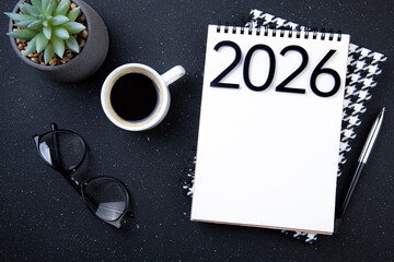 New year goals 2026 on desk. 2026 resolutions list with notebook, plant on black table. Resolutions, plan, goals, action, checklist, idea concept. New Year 2026 resolutions, copy space