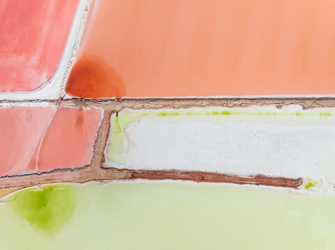 Aerial view of levee banks dividing colourful salt evaporation ponds