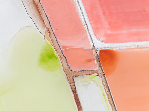 Aerial view of levee banks dividing colourful salt evaporation ponds