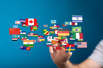 Diverse flags floating in the air above a hand, symbolizing concepts like world peace, collaboration, and global unity. Ideal for illustrating i