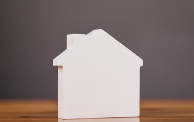 Naklejka na ściany i meble A white wooden model house sits on a wooden surface against a neutral background, ideal for real estate and homeownership concepts. Naklejka na ściany i meble A white wooden model house sits on a wooden surface against a neutral background, ideal for real estate and homeownership concepts.