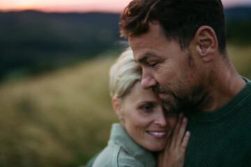 Portrait of romantic couple in nature during sunset.