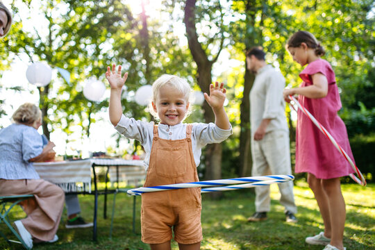 Toddler boy playing with hula hoop, having fun during family picnic.