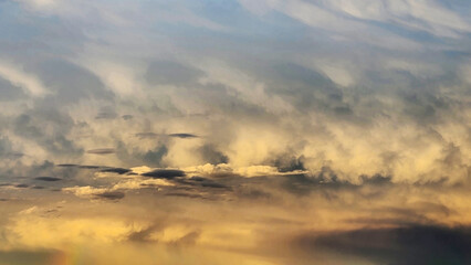 A golden evening sky after rain, where soft clouds and lingering moisture scatter the sunlight into...