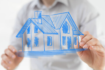 A hand drawing a house blueprint, representing real estate, construction, and future home concepts....