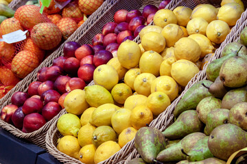 Lemons and nectarines lie in baskets on the counter, standing out with rich colors.