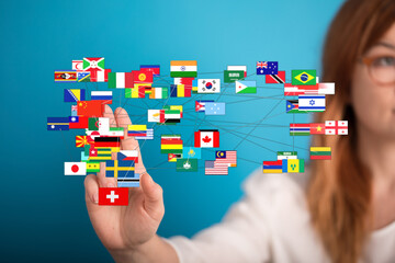 Woman's hand touching international flags, symbolizing global connectivity, communication, and unity across diverse cultures. Concept of travel,