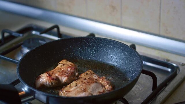 Close-up of pork frying in a pan for traditional Peruvian dish Pan con Chicharron. Street food preparation, authentic Latin American cuisine, sizzling meat cooking concept.