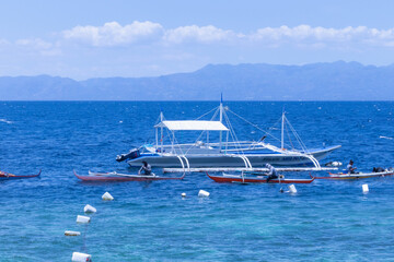 Scenic Seascape with Outrigger Boats and Distant Mountains in the Philippines