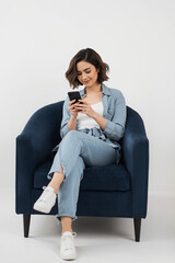 Woman in yellow jacket holding smartphone isolated on transparent background