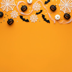 Cornice a tema Halloween su sfondo arancione con ragnatele, zucche nere e bianche, pipistrelli e coriandoli a stella.