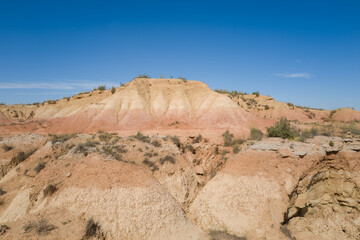 This landscape photo was taken in Europe, Spain, Navarre, in summer. It shows the rocks in the Bardenas Reales, under the Sun.
