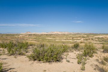 This landscape photo was taken in Europe, Spain, Navarre, in summer. It shows the arid field in the Bardenas Reales, under the Sun.