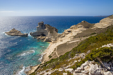 cap Pertusato with deep blue turquoise sea and small beach with sunny skies