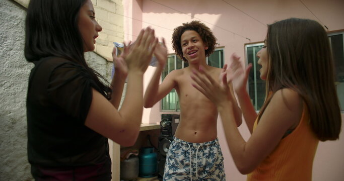 Siblings playing rhythmic hand-clapping game, energetic courtyard fun, carefree childhood, bonding moment, joyful synergy, laughter, shared happiness