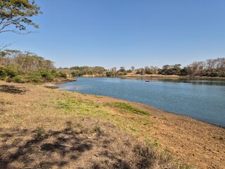 View of a river in the interior of Brazil (Tietê), showing the riverbank and a blue sky.