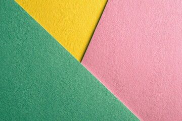 Geometric arrangement featuring intersecting planes of vibrant green, yellow, and pink paper