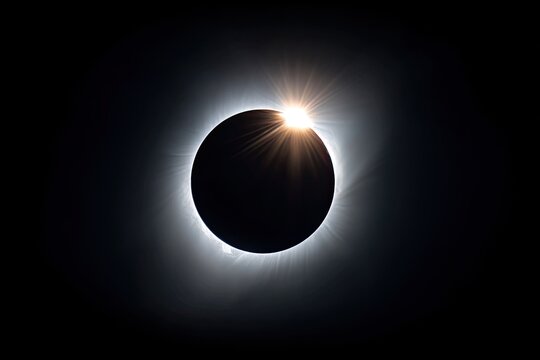 Stunning view of a total solar eclipse, with corona and bright sunlight around the dark moon