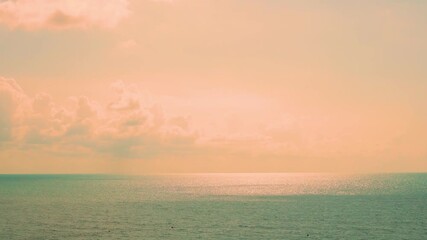 Sunset sea in sunlight yelow orange peach sky colored plump clouds and sun. Colorful dawn sky sun clouds beach horizon, turquoise ocean bay vacation seascape island relax paradise. - Powered by Adobe