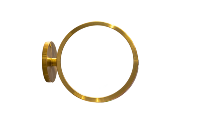 A golden circular frame with a blank white center attached to a wall fixture, isolated on black