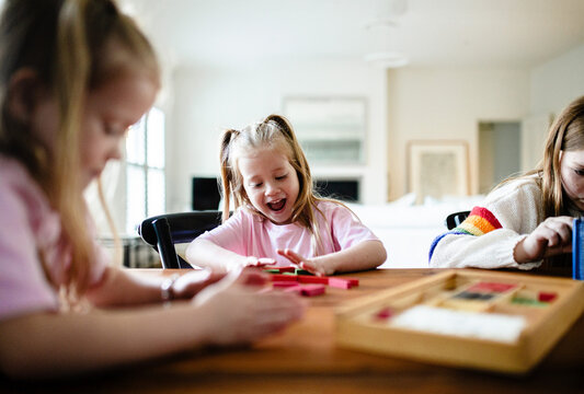 Young girls playing colourful rectangular blocks on the table