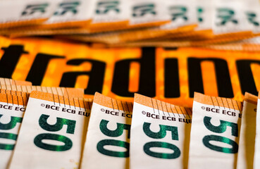 close up 50 euros banknotes and the word "trading"