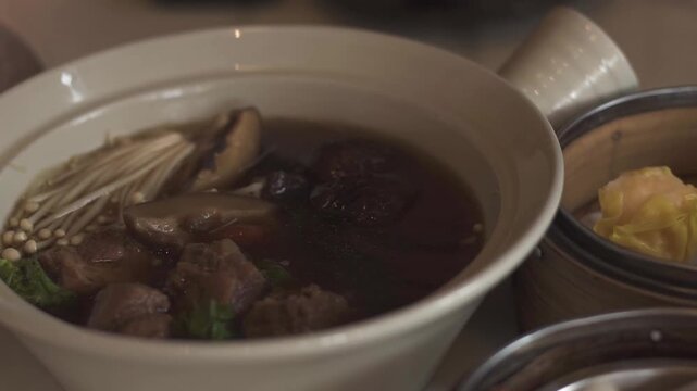 Bak-kut-teh is a pork rib dish.Dim Sum is traditional chinese food, people traditionally enjoy in restaurants for breakfast and lunch. Close up of Steamed Dim Sum in bamboo dish at chinese restaurants