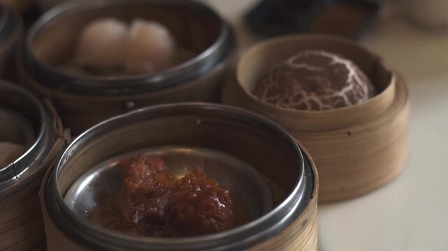 A close-up shot of various dim sum dishes served in traditional bamboo steamers at Dim Sum restaurant. Cinematic lighting. Delicious dim sum, Chinese food.