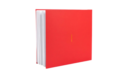 A hardcover book with red cover, white pages, and subtle orange text against a black background