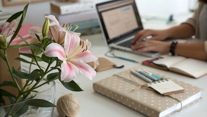Pink and White Bauhinia Flowers in Vase Beside Woman Typing on Laptop with Gifts and Notebooks pink flowers