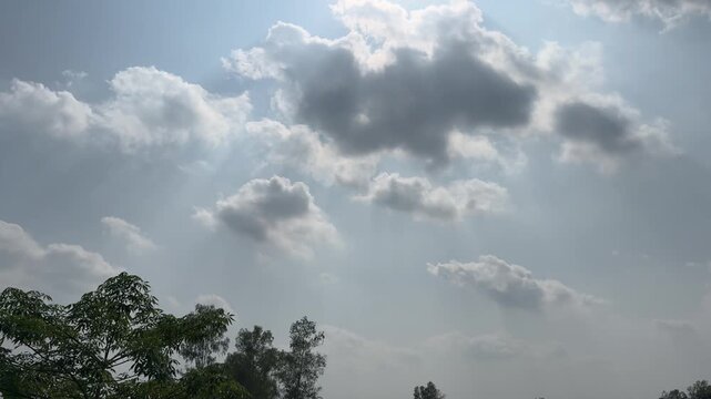 Bright Sky with Sun Peeking Through Dramatic Cumulus Clouds