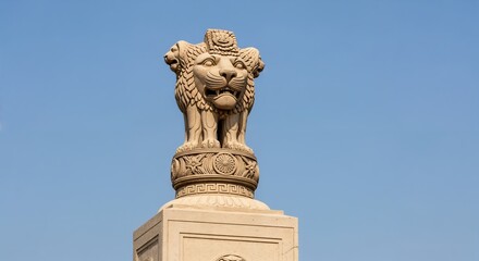 Obraz premium The Lion Capital of Ashoka: A Historical Stone Sculpture Featuring Four Lion Figures Representing Power and Unity Against a Clear Blue Sky