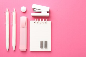 Stapler and other stationery on pink background, flat lay. Space for text