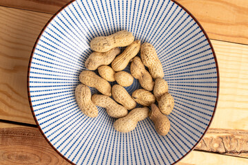 Unshelled raw peanuts, macro, top view.