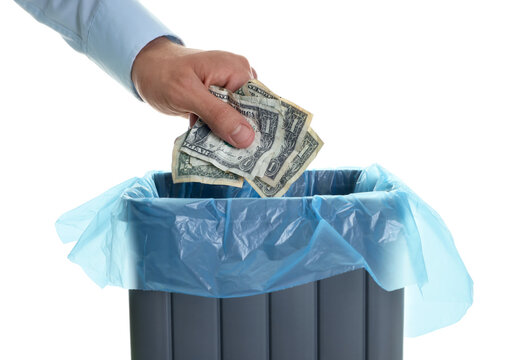 Man throwing money into trash bin on white background, closeup
