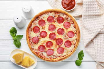 Delicious pepperoni pizza and ingredients on white wooden table, flat lay