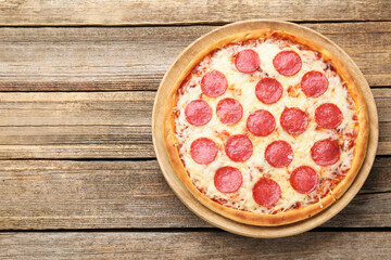 Delicious pepperoni pizza on wooden table, top view. Space for text