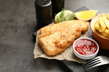 British Traditional Fish and chips served with sauce on grey table, closeup