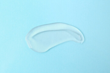 Sample of cosmetic product on light blue background, top view